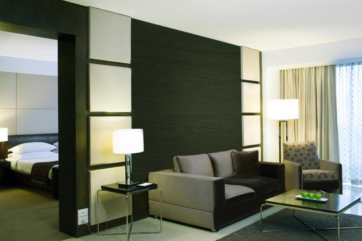 a hotel room with a couch and a bed at Radisson Blu Hotel Pune Kharadi in Pune