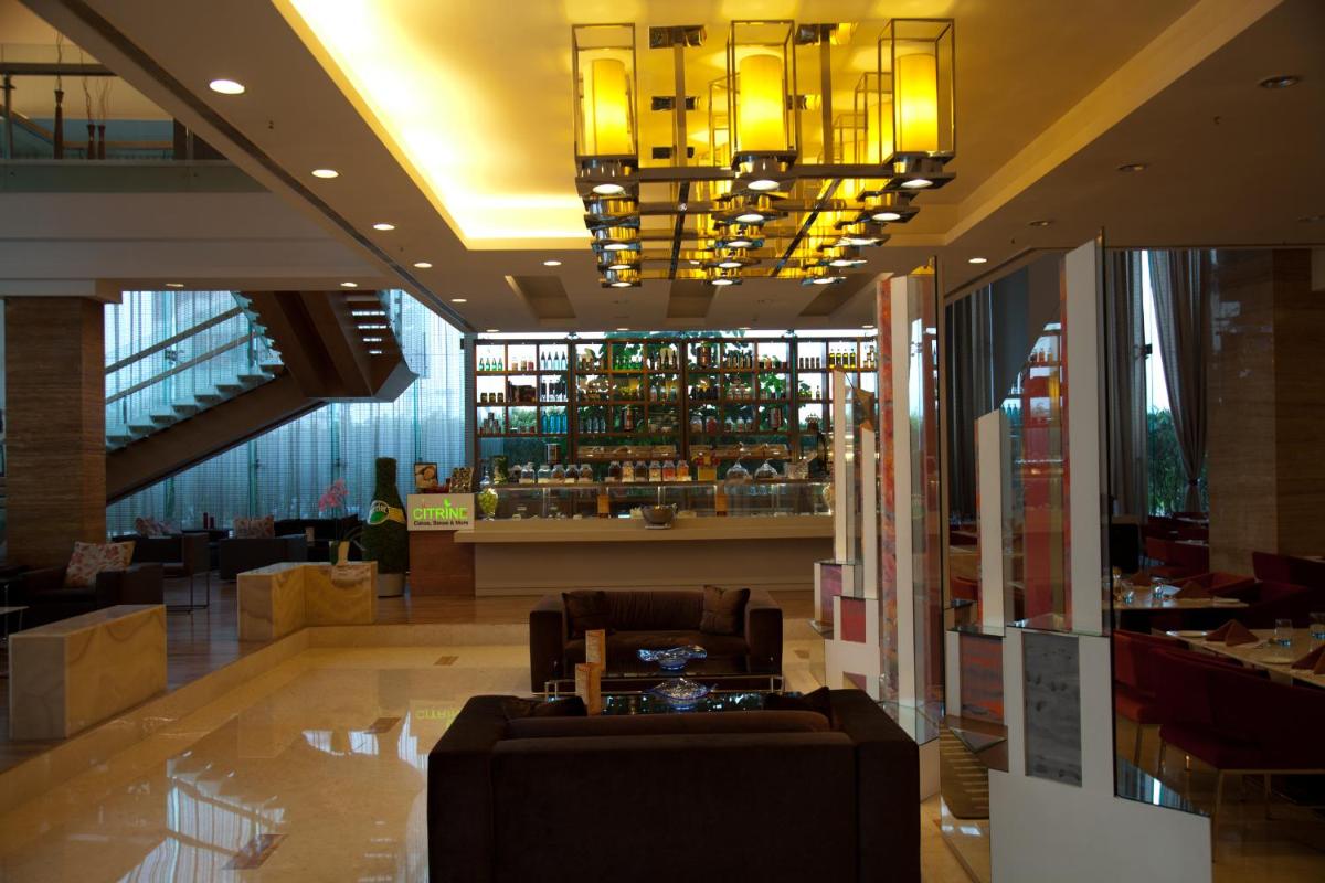 a lobby with a couch and a bar in a building at Radisson Blu Hotel Pune Kharadi in Pune