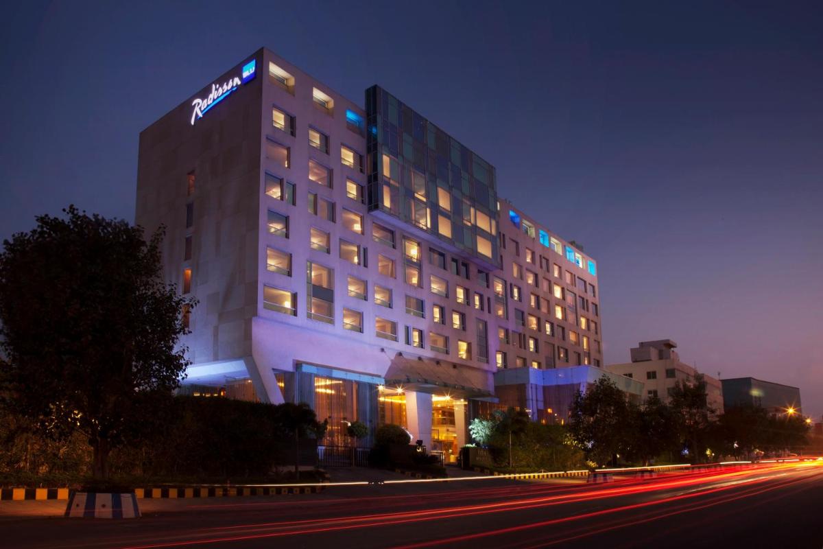 a hotel with a sign on the side of a building at Radisson Blu Hotel Pune Kharadi in Pune