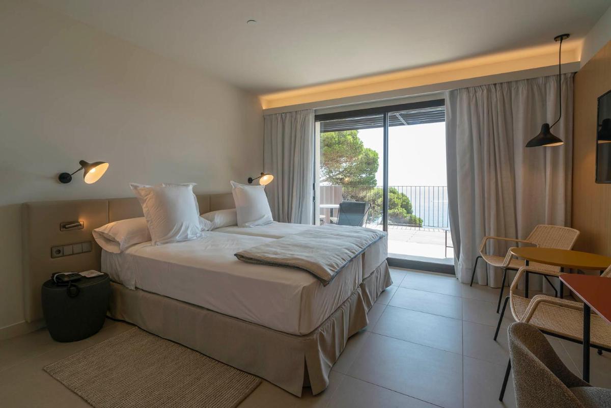 Un dormitorio con una cama grande y una ventana grande. en Parador de Aiguablava, en Begur 26 fotos más