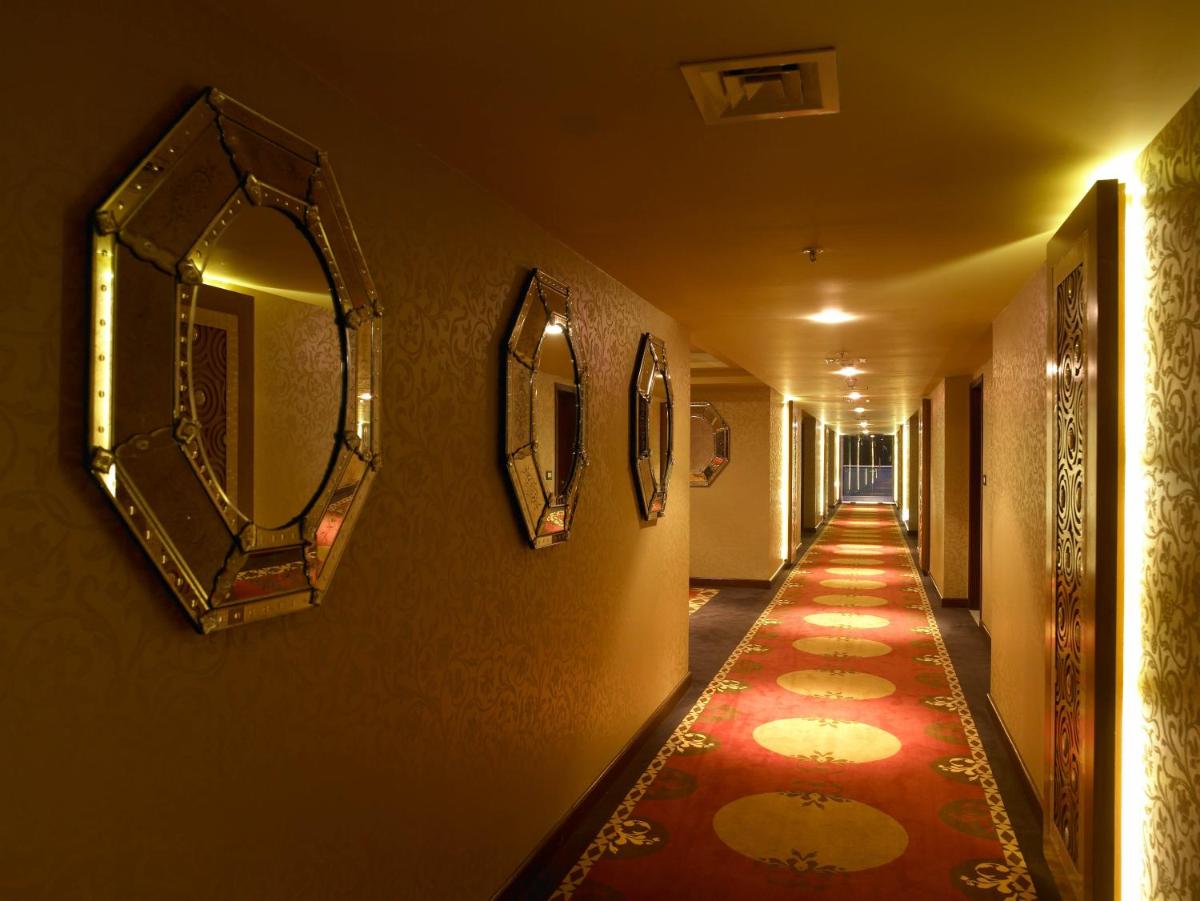 a long hallway with mirrors and a red carpet at The Zuri Whitefield Bengaluru in Bengaluru