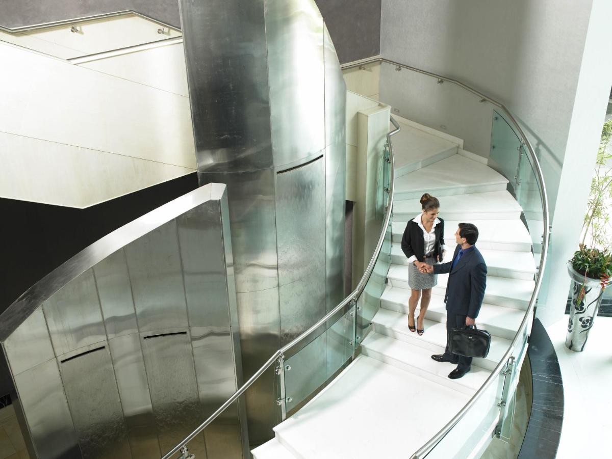 two people are standing on a spiral staircase at The Zuri Whitefield Bengaluru in Bengaluru