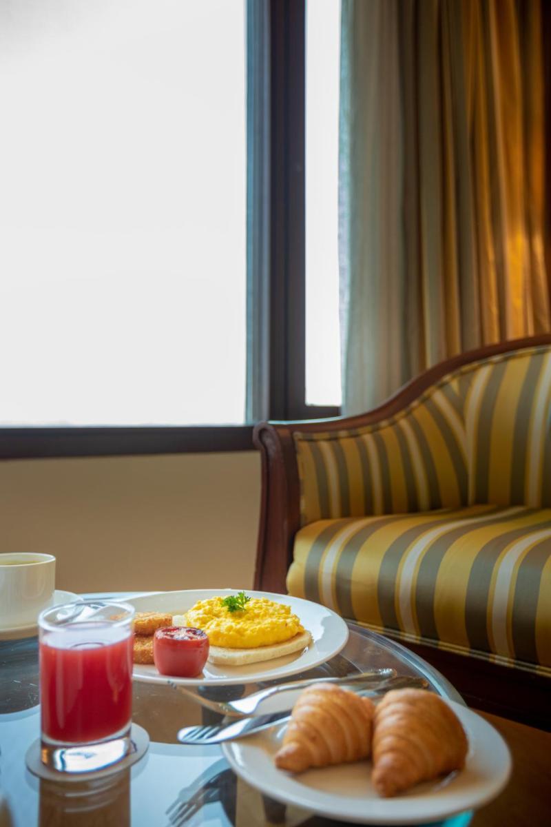 a table with two plates of food and croissants at The Orchid Hotel Mumbai Vile Parle in Mumbai
