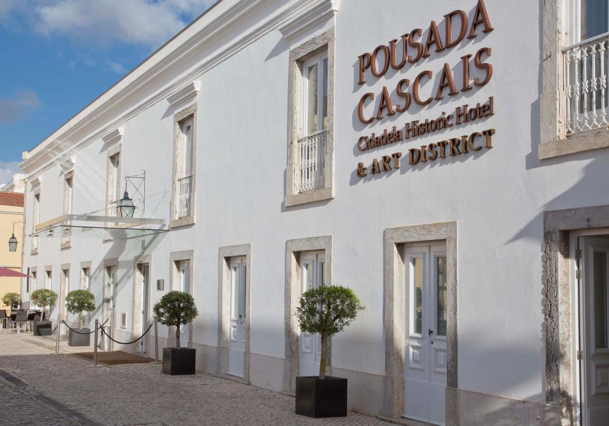 um prédio branco com árvores na frente em Pestana Cidadela Cascais - Pousada & Art District em Cascais