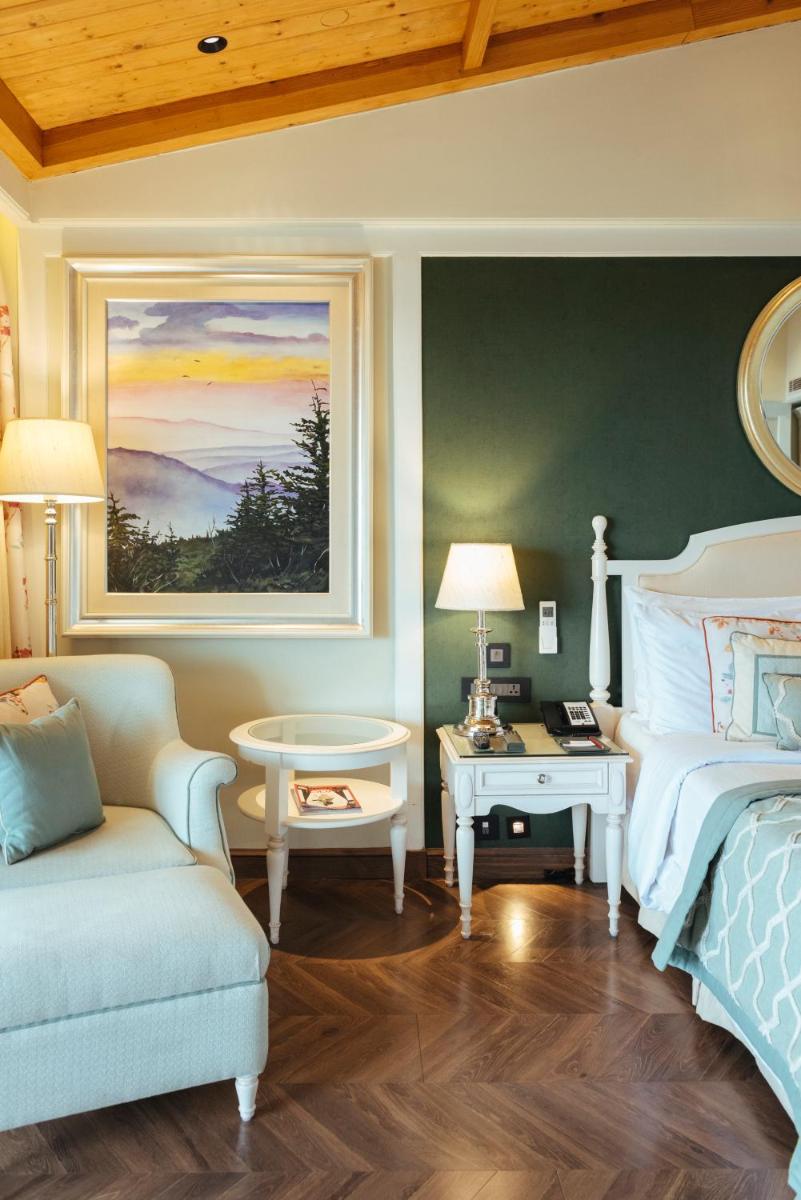 a bedroom with a bed and a couch and a table at Welcomhotel by ITC Hotels, The Savoy, Mussoorie in Mussoorie