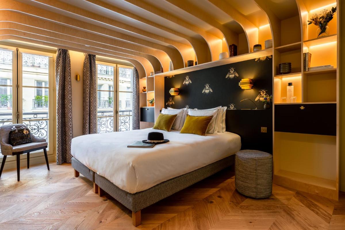 une chambre avec un grand lit dans une pièce dans l'établissement Bonsoir Madame, à Paris une chambre avec un grand lit dans une pièce dans l'établissement Bonsoir Madame, à Paris