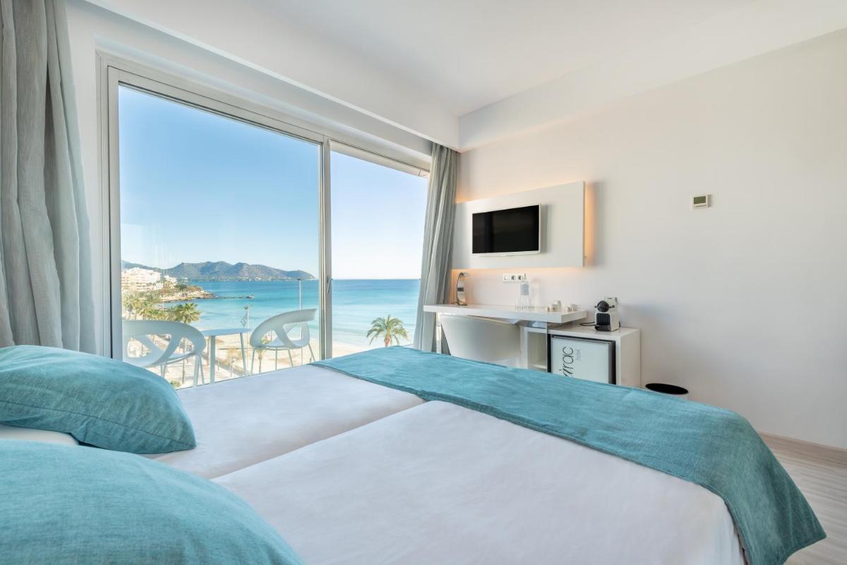 Un dormitorio con una cama y una ventana grande. en Kyrat Amarac - Adults Only, en Cala Millor