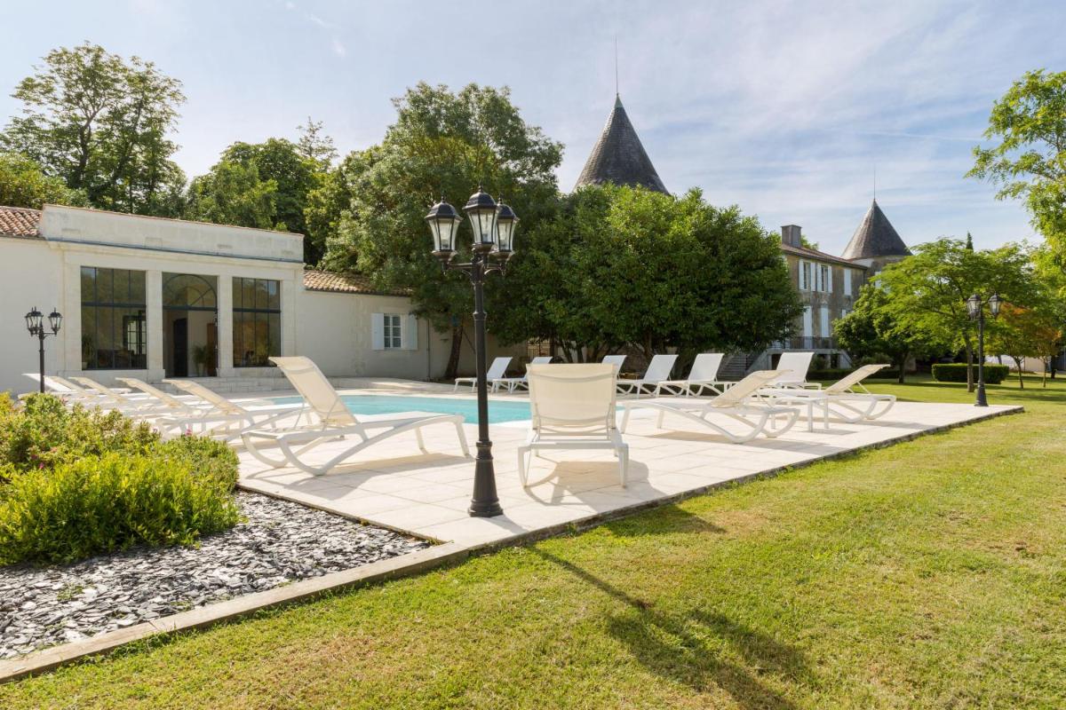 - un groupe de chaises assises autour d'une piscine dans l'établissement Le Logis du Péré, à Saint-Coutant-le-Grand