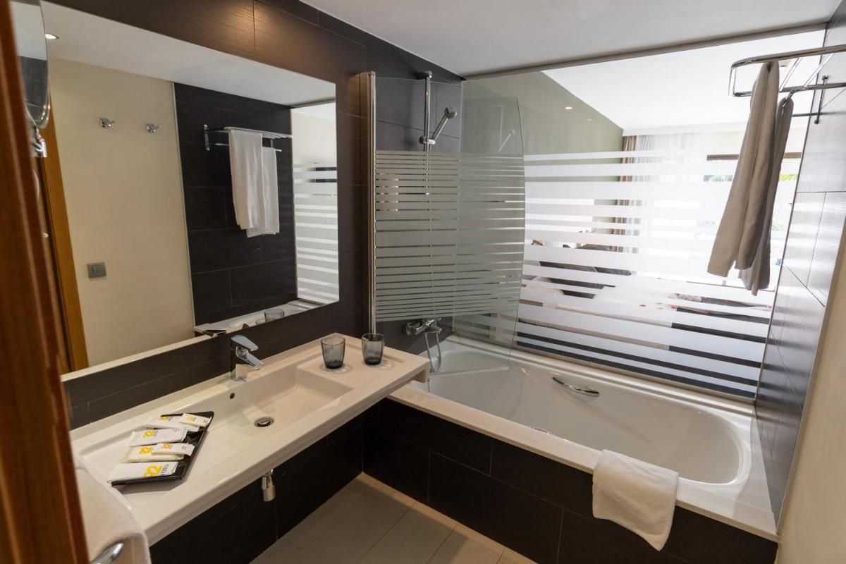 Un baño con una bañera grande y un lavabo. en R2 Romantic Fantasia Suites - Adults Only, en Tarajalejo