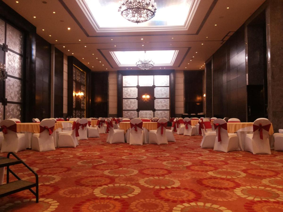 a banquet hall with tables and chairs in a room at The Pllazio Hotel in Gurgaon