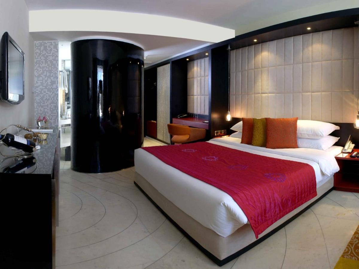 a bedroom with a large bed with a red blanket at The Park Kolkata in Kolkata