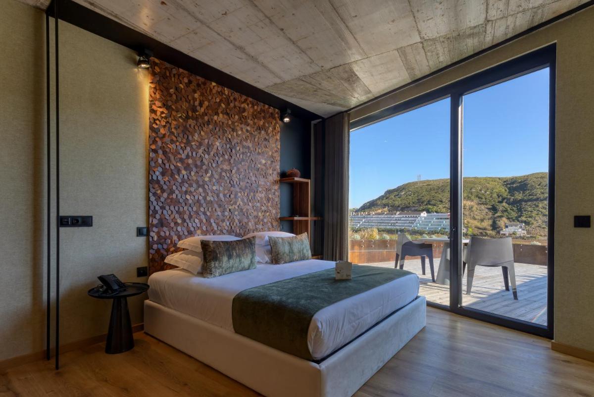 um quarto com uma cama grande e uma janela grande em Well Hotel & Spa em Maceira