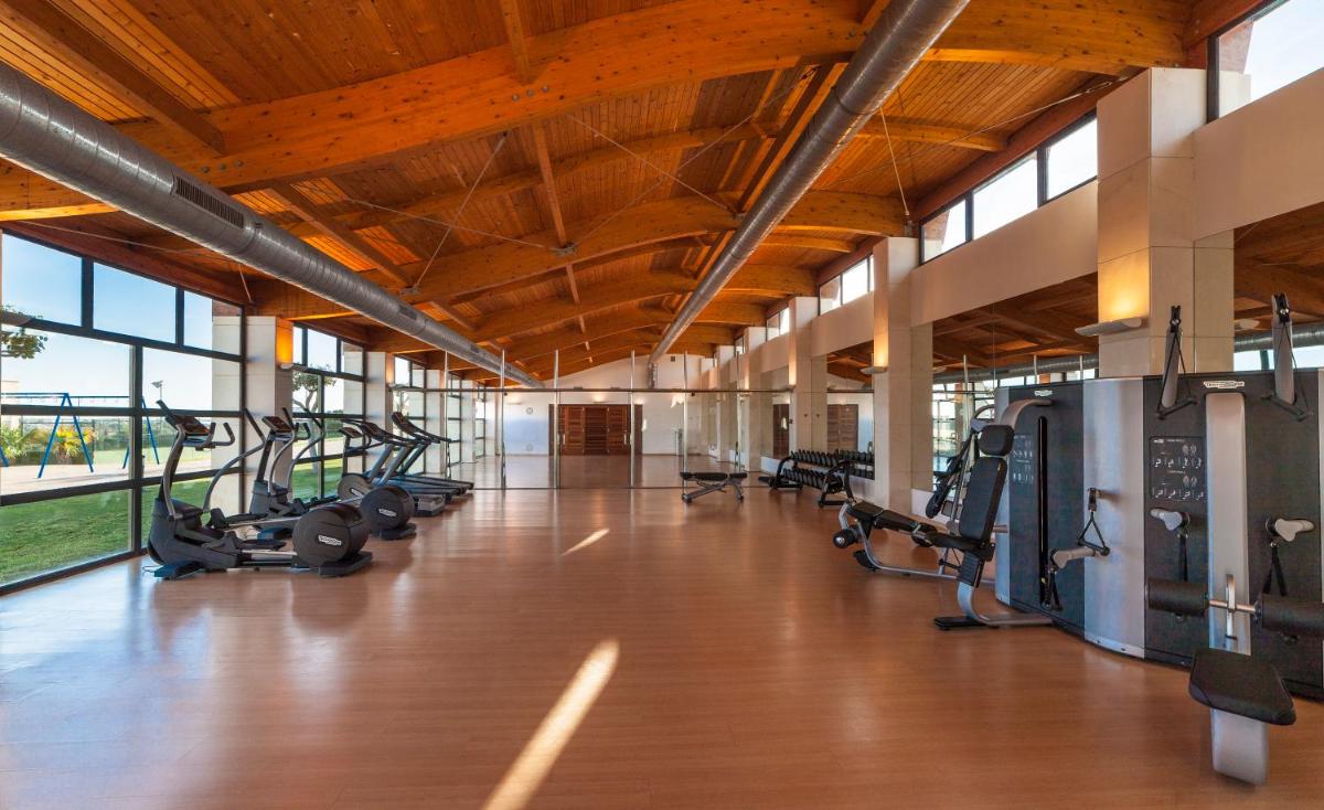 Un gimnasio con cintas de correr y equipos cardiovasculares en un edificio. en Insotel Punta Prima Prestige Suites & Spa, en Punta Prima