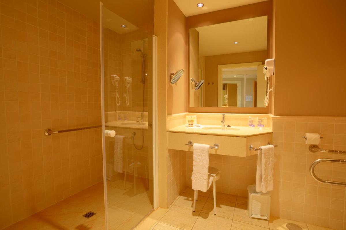 Un baño con lavabo, ducha y espejo. en Hotel Valle del Este, en Vera