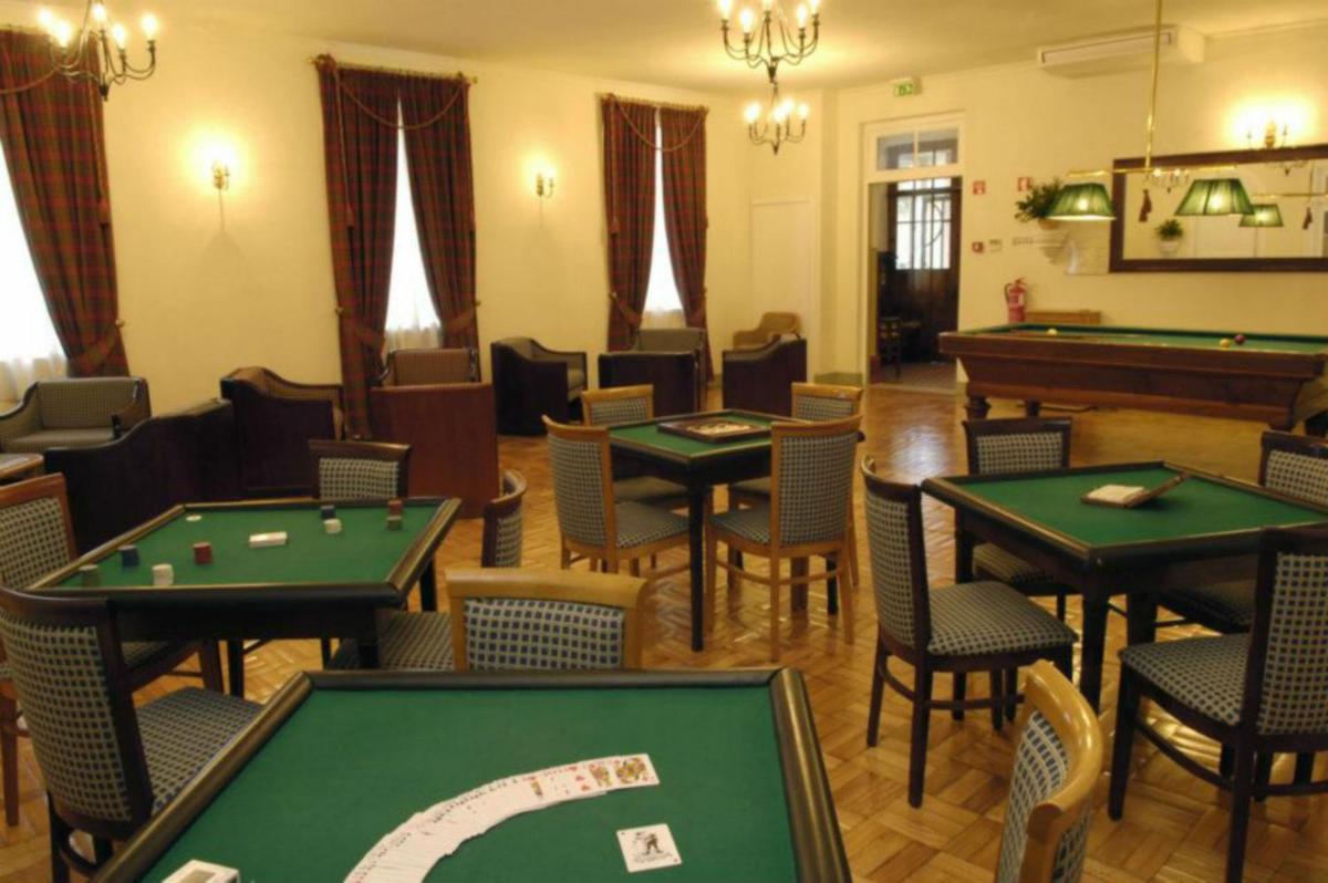 uma sala com mesas e cadeiras de bilhar e uma mesa de sinuca em Palace Hotel & Spa - Termas de Sao Vicente em Penafiel