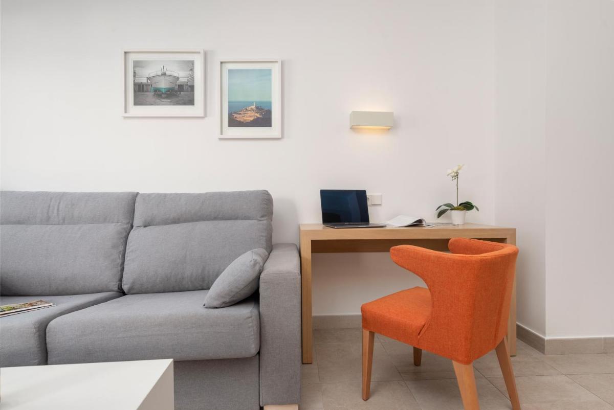 Una sala de estar con un sofá y un escritorio con una silla. en Trendhotel Alcudia - Adults Only, en Puerto de Alcudia 39 fotos más