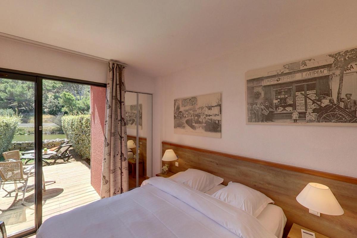 une chambre avec un lit et un balcon dans l'établissement Hotel Le Phoebus Garden & Spa, à Gruissan 32 autres photos