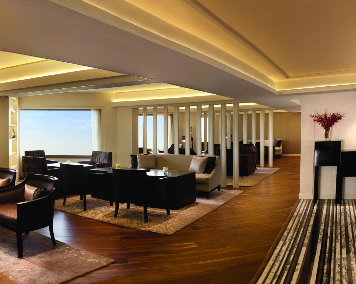 a hotel lobby with tables and chairs at Hyatt Regency Delhi in New Delhi a hotel lobby with tables and chairs at Hyatt Regency Delhi in New Delhi