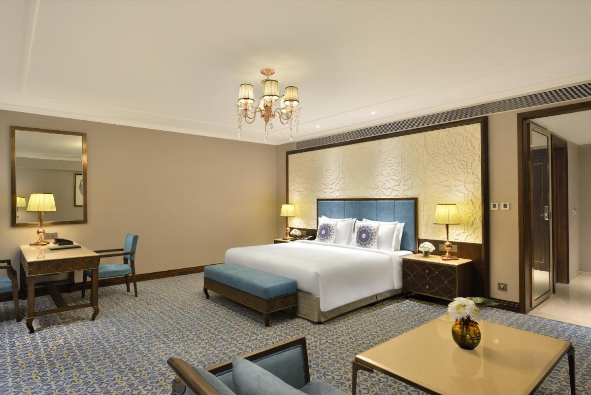 a large hotel room with a bed and a desk at Taj Skyline Ahmedabad in Ahmedabad