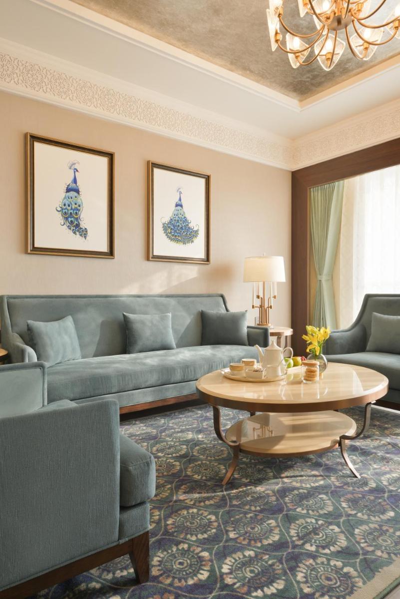 a living room with blue couches and a table at Taj Skyline Ahmedabad in Ahmedabad
