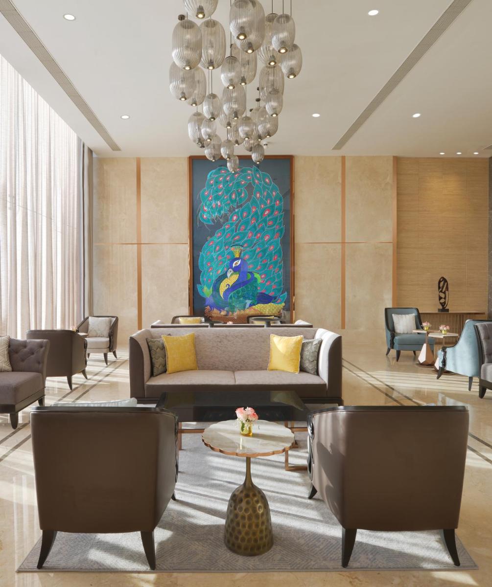 a living room with a couch and a chandelier at Taj Skyline Ahmedabad in Ahmedabad