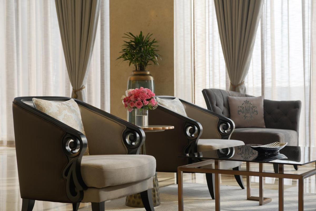 a living room with two chairs and a coffee table at Taj Skyline Ahmedabad in Ahmedabad