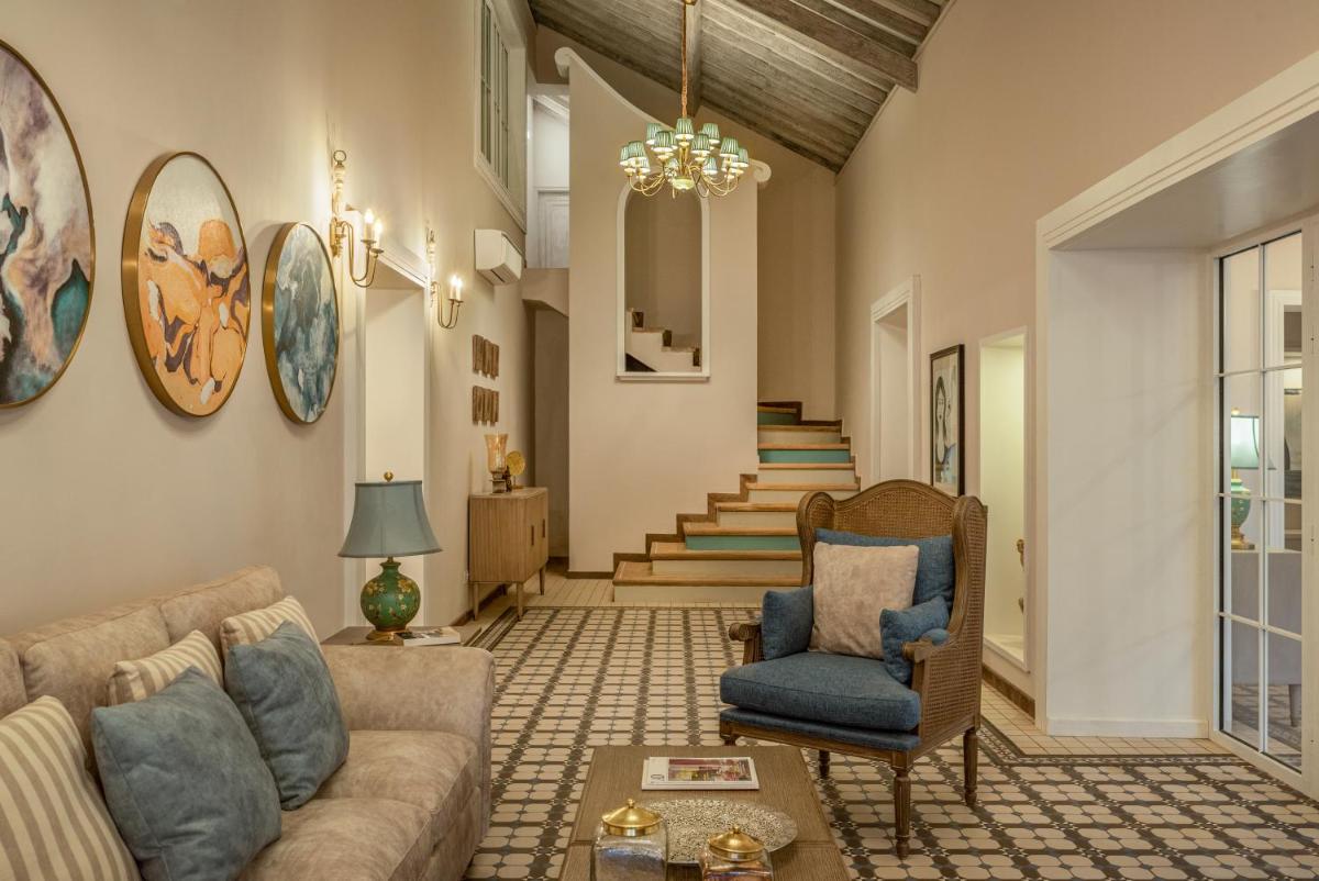 a living room with a couch and a chair at MansionHaus in Anjuna