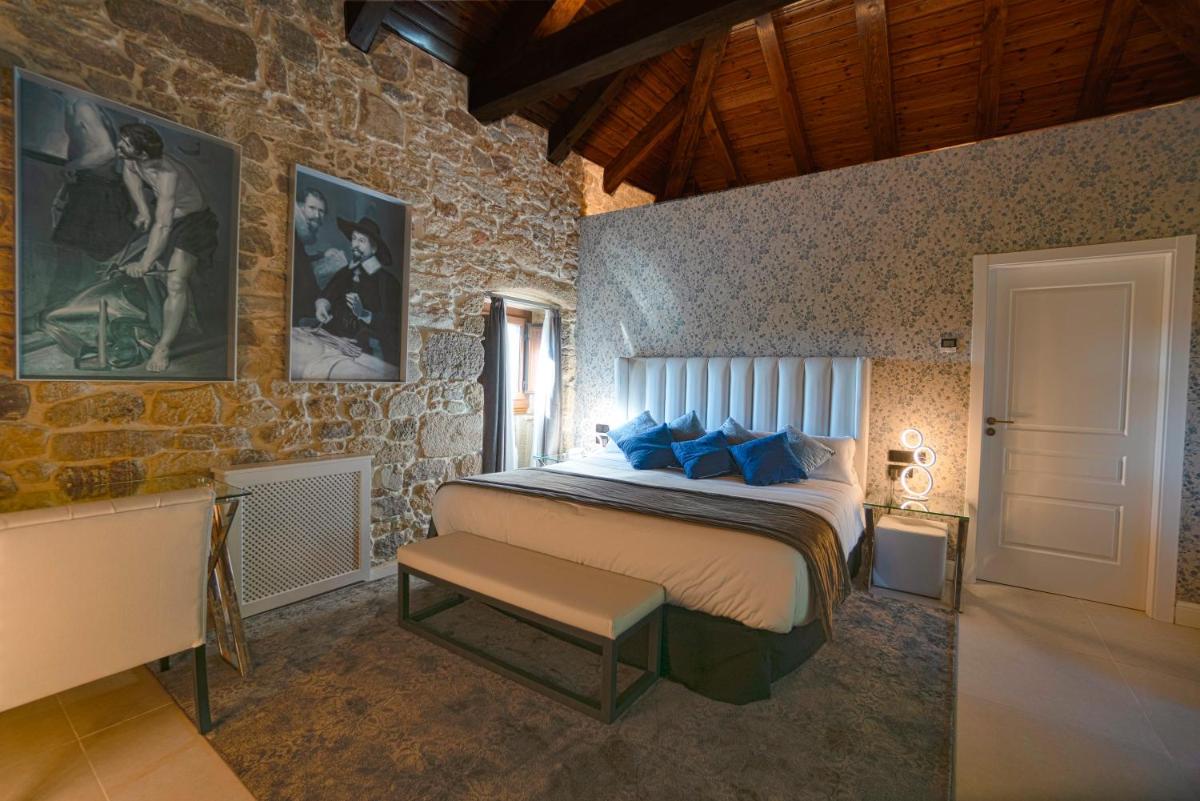Un dormitorio con una cama grande con almohadas azules. en Hotel As Torres da Hermida, en Monterroso