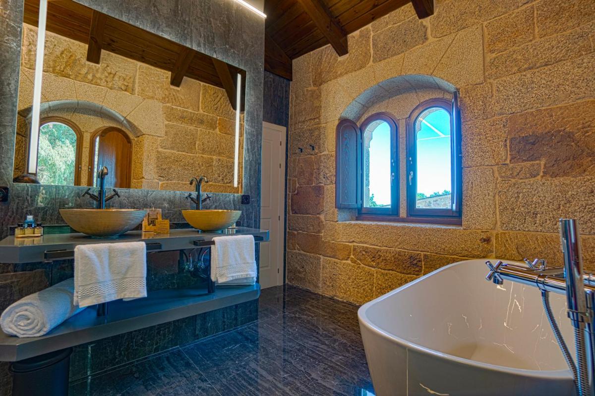 Un baño con dos lavabos y una bañera. en Hotel As Torres da Hermida, en Monterroso 57 fotos más