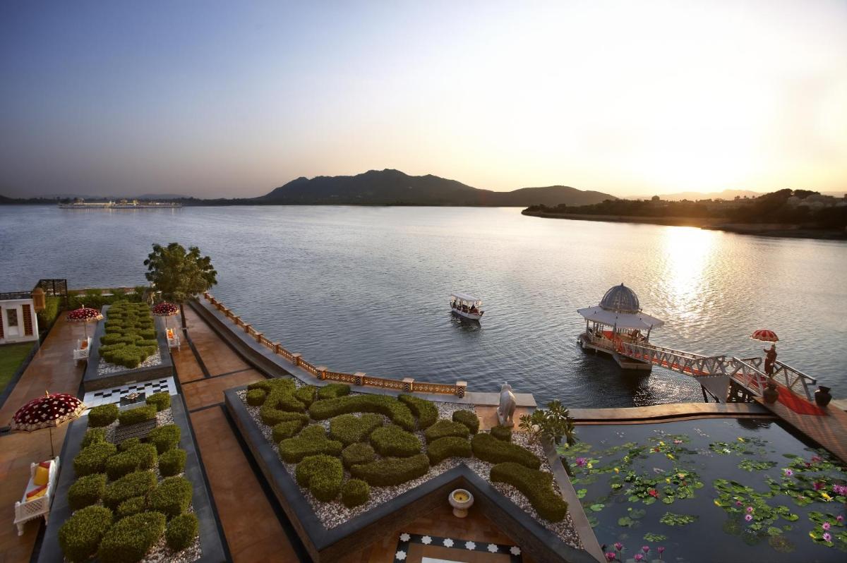 a view of a lake with a boat in the water at The Leela Palace Udaipur in Udaipur