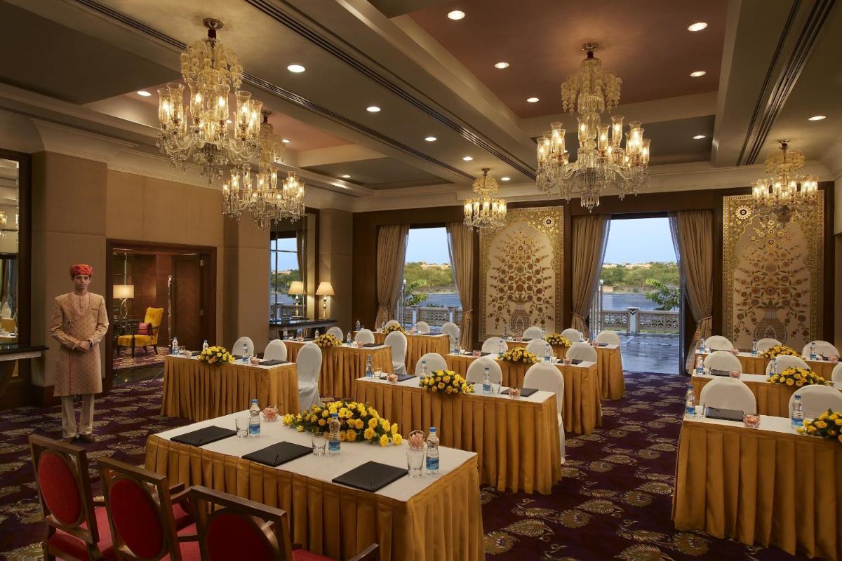 a conference room with tables and chairs and a man standing in front at The Leela Palace Udaipur in Udaipur +81 photos