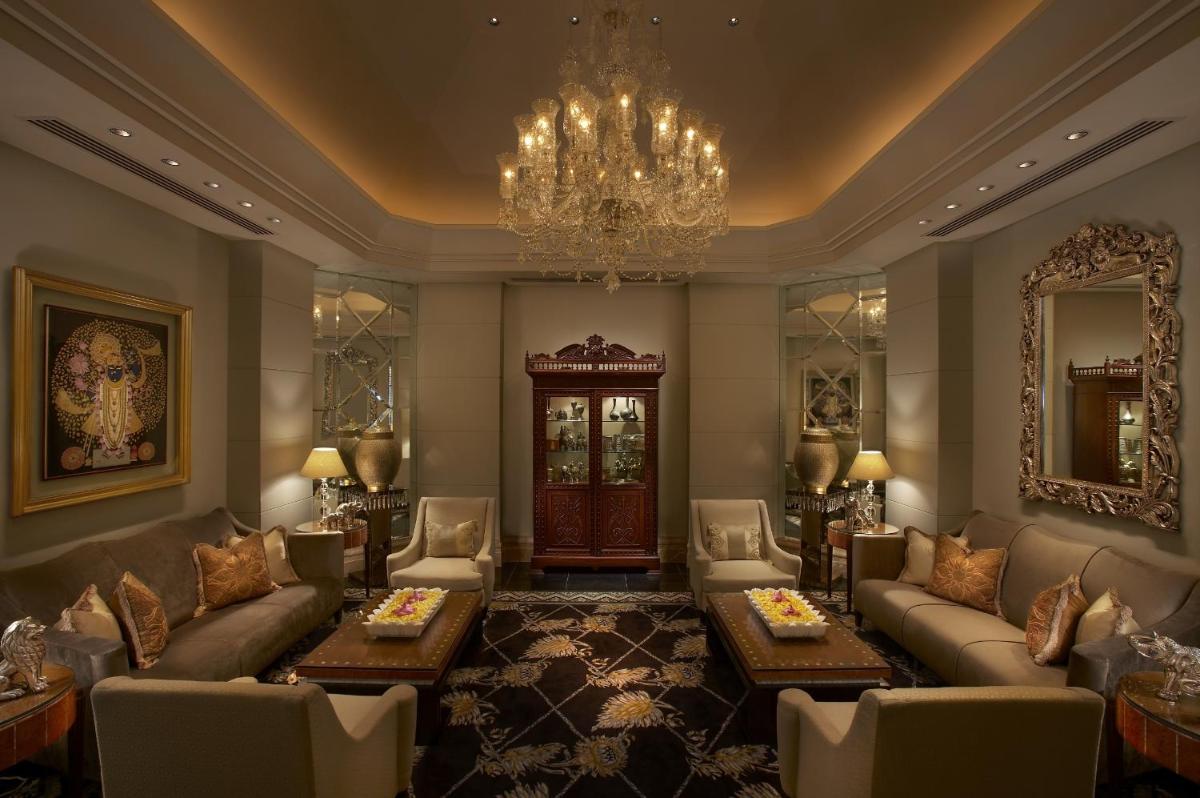 a living room with couches and a chandelier at The Leela Palace Udaipur in Udaipur