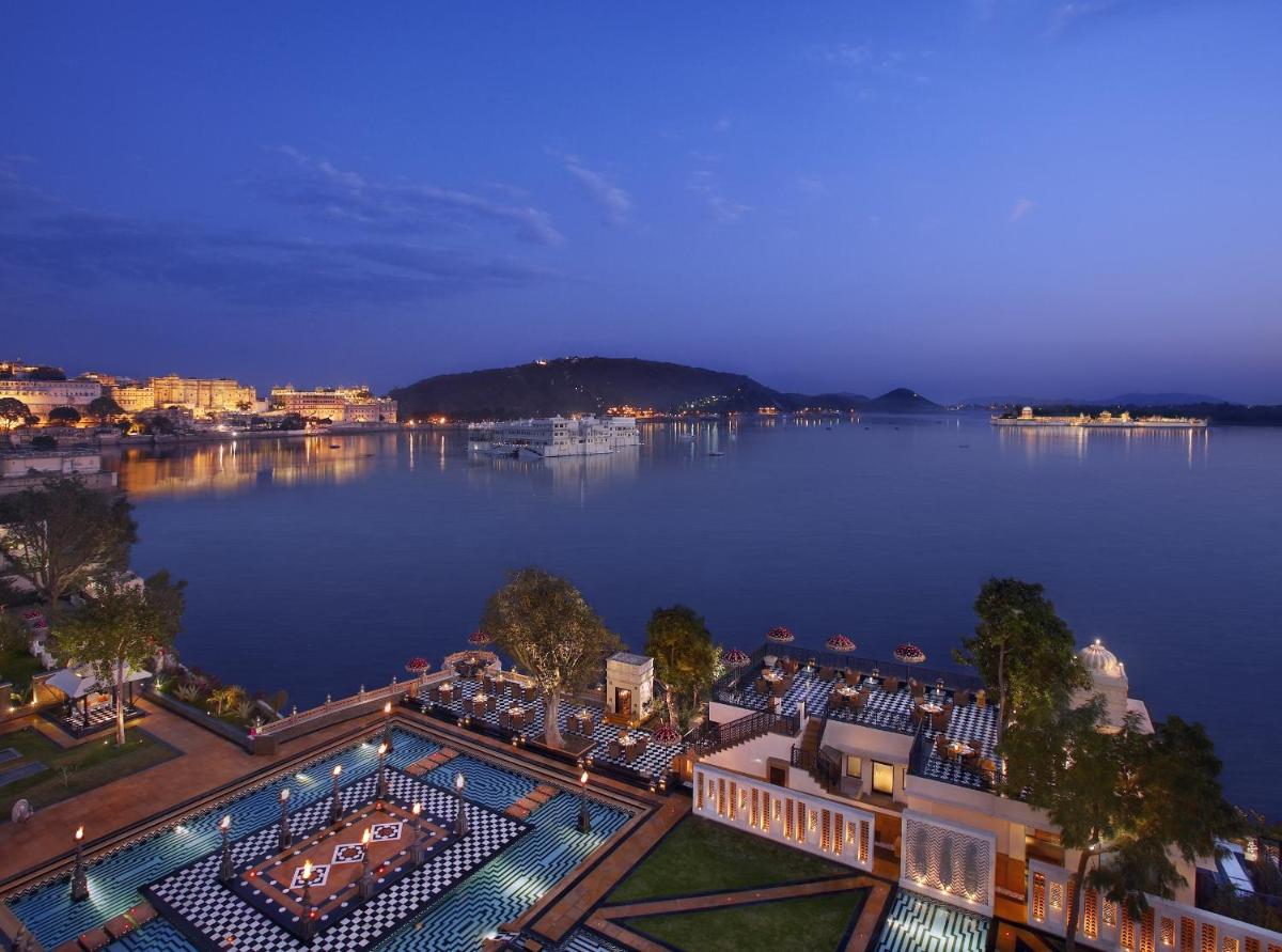 an aerial view of a large lake at night at The Leela Palace Udaipur in Udaipur