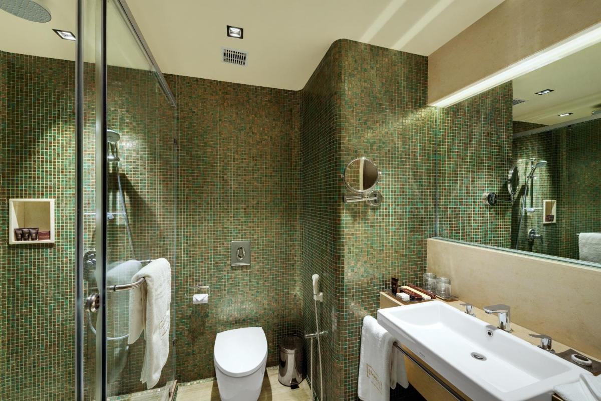 a bathroom with a toilet and a sink and a shower at Wyndham Ahmedabad Shela in Ahmedabad
