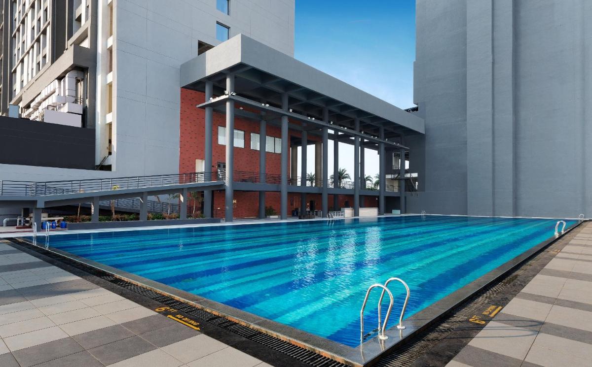 a large swimming pool in front of a building at Wyndham Ahmedabad Shela in Ahmedabad