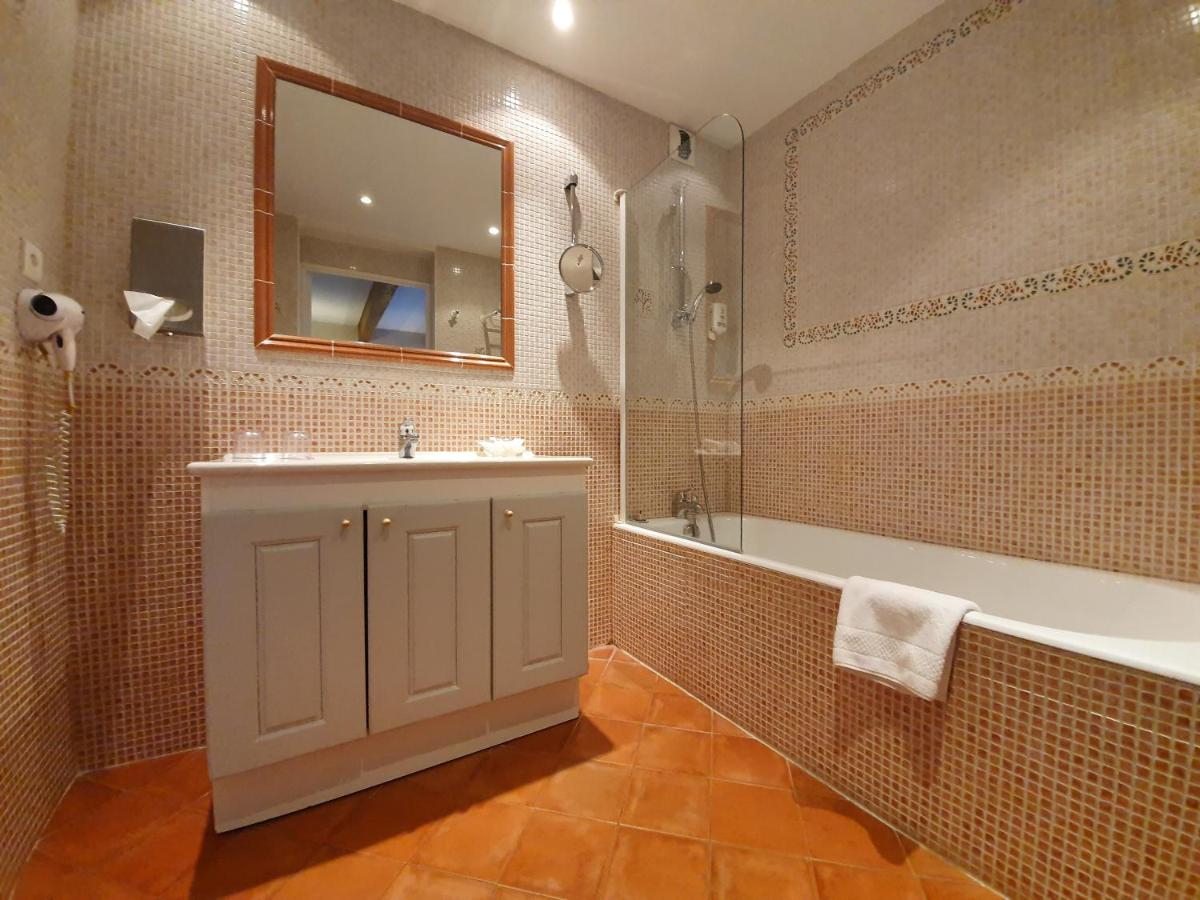 une salle de bain avec une baignoire, un lavabo et un miroir dans l'établissement Le Chalet Suisse, à Valberg 43 autres photos