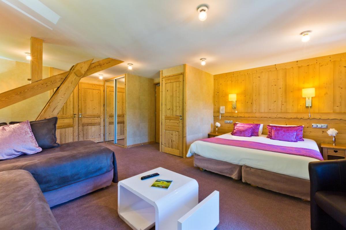 une chambre d'hôtel avec deux lits et un canapé dans l'établissement Aiguille du Midi - Hôtel & Restaurant, à Chamonix-Mont-Blanc