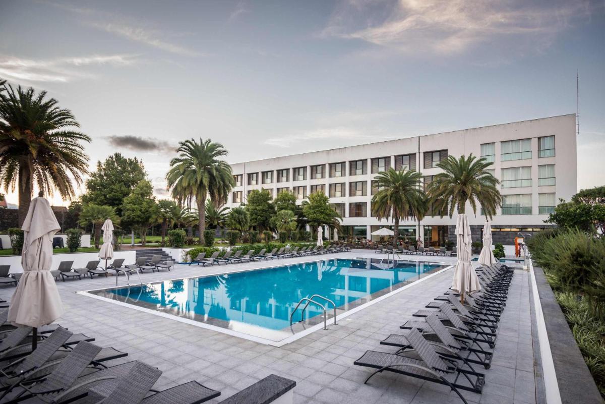 um hotel com piscina e cadeiras e um prédio em Azoris Royal Garden – Leisure & Conference Hotel em Ponta Delgada