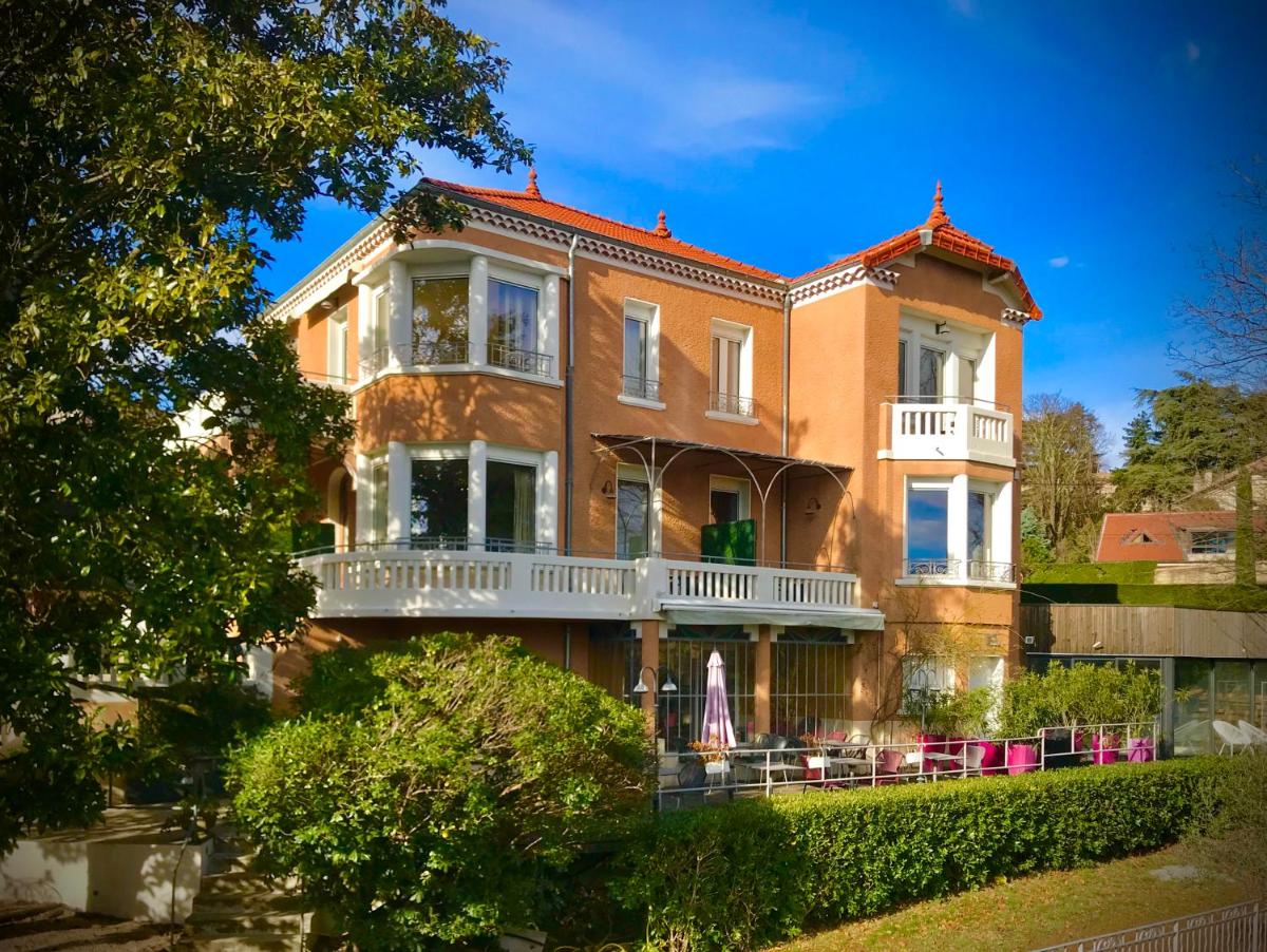 une grande maison en briques avec un balcon blanc dans l'établissement Villa Elisa M, à Aubenas