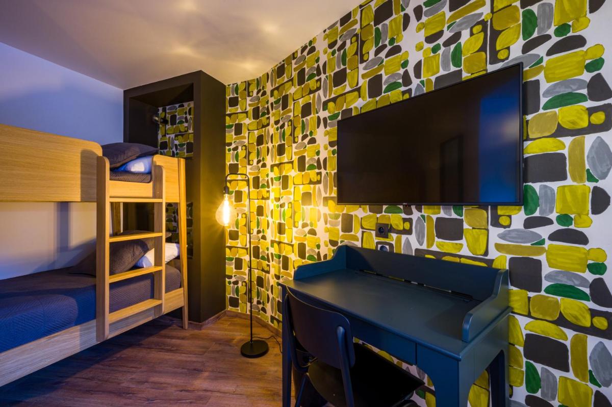 Cette chambre dispose d'une télévision et d'un mur recouvert de carrelage coloré. dans l'établissement L'Outa Hotel Restaurant, à Termignon 127 autres photos