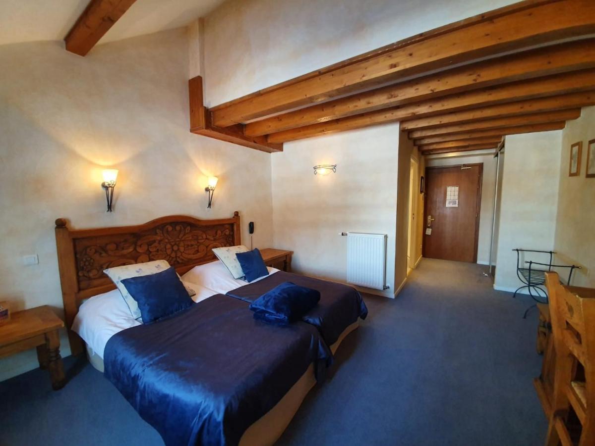 une chambre avec un grand lit avec des oreillers bleus dans l'établissement Le Chalet Suisse, à Valberg
