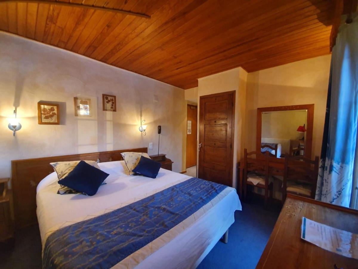 - une chambre avec un grand lit et un plafond en bois dans l'établissement Le Chalet Suisse, à Valberg