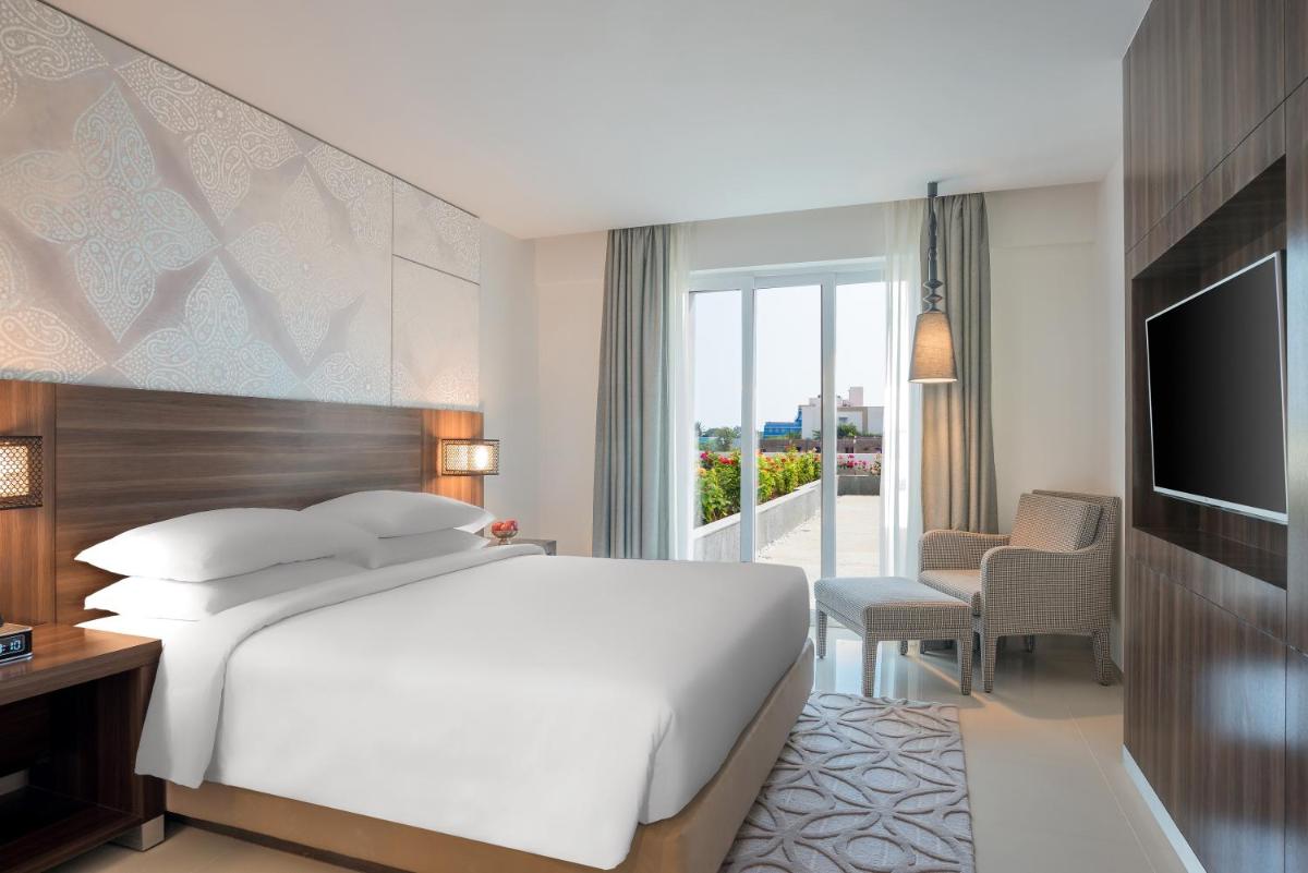 a bedroom with a white bed and a television at The Residency Towers, Rameswaram in Rāmeswaram