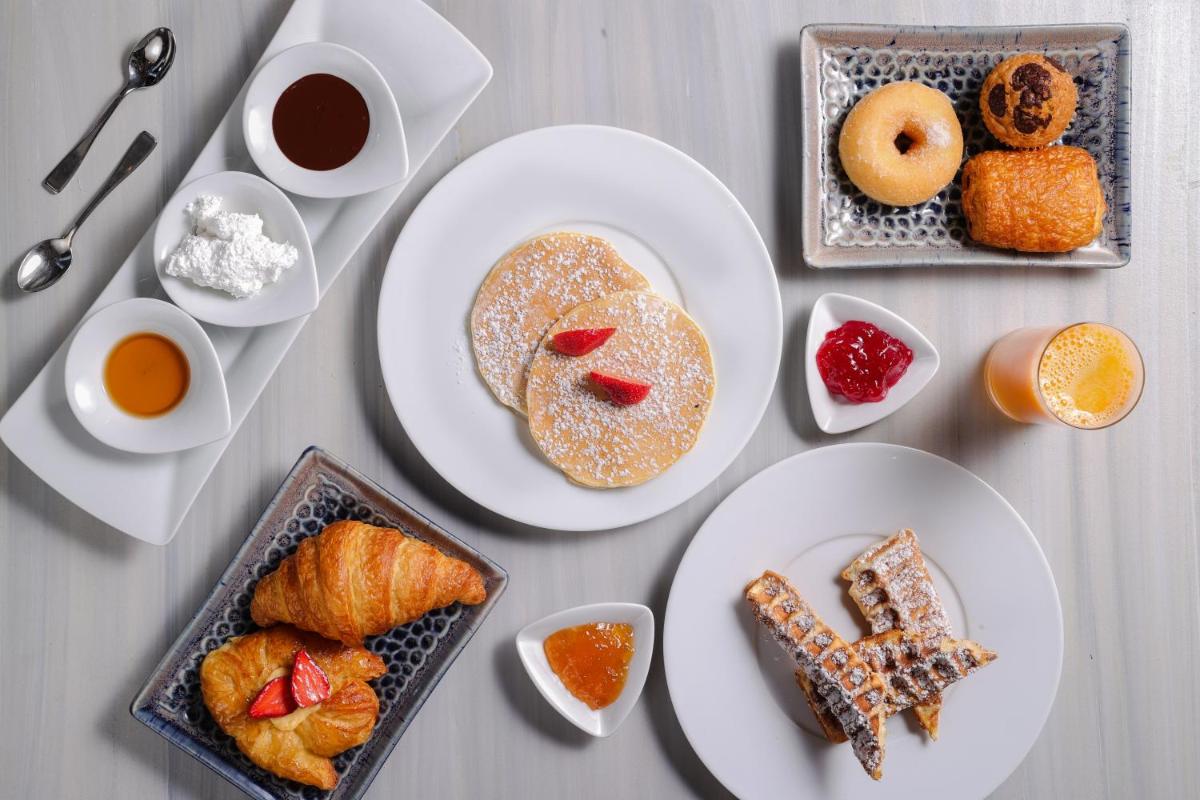 a table with plates of pastries and other breakfast foods at The Lodhi – A member of The Leading Hotels Of The World in New Delhi