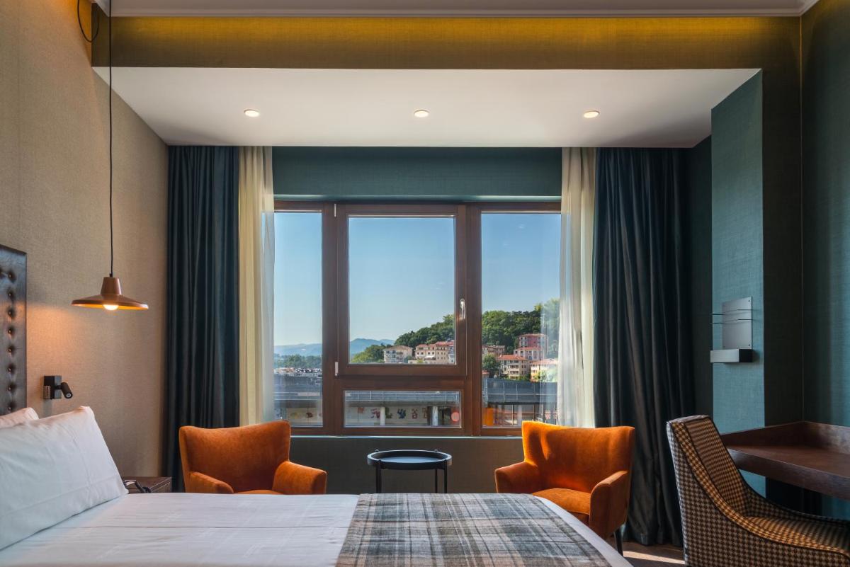 Una habitación de hotel con una cama y una ventana grande. en Catalonia Donosti, en San Sebastián