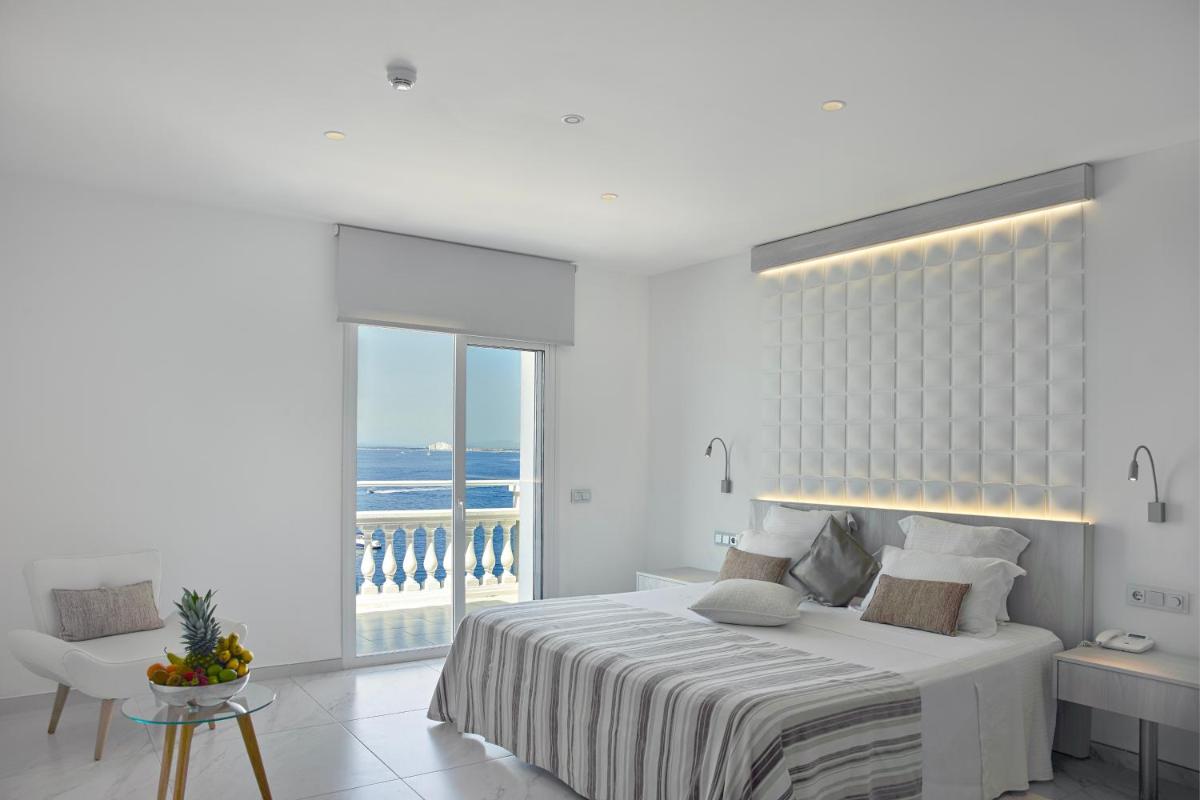 Un dormitorio blanco con una cama grande y un balcón. en Hotel Vistabella, en Roses