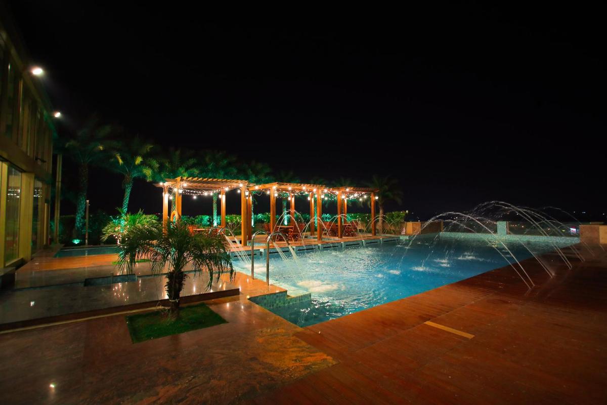 a swimming pool at night with lights around it at Seven Seas Hotel in New Delhi
