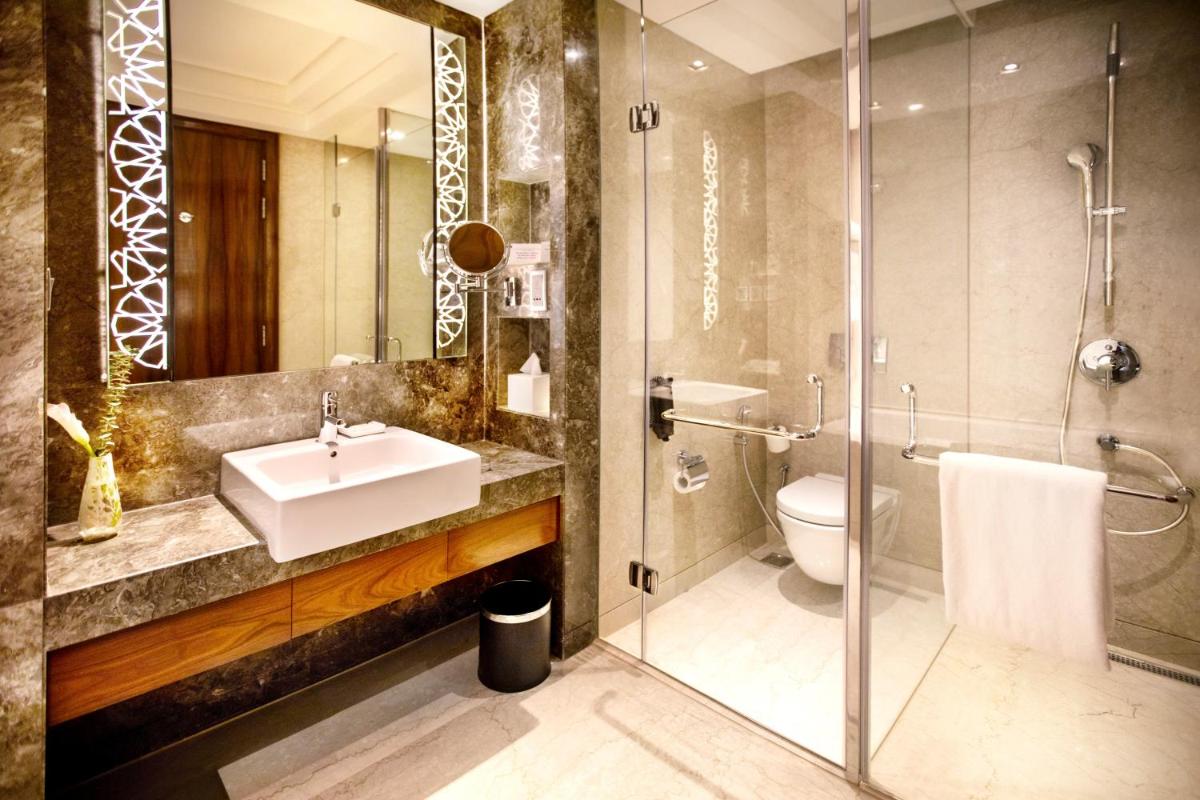 a bathroom with a sink and a shower and a toilet at Crowne Plaza New Delhi Rohini by IHG in New Delhi a bathroom with a sink and a shower and a toilet at Crowne Plaza New Delhi Rohini by IHG in New Delhi