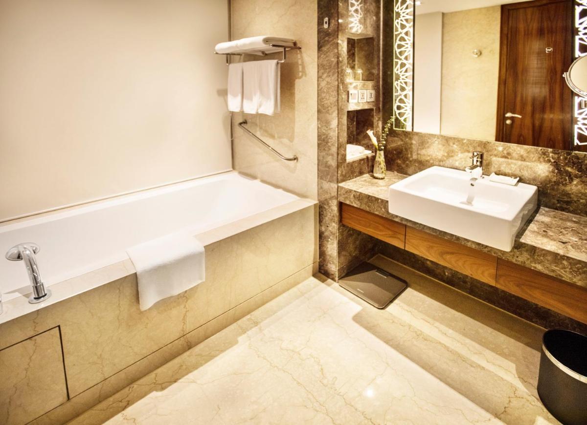 a bathroom with a sink and a mirror at Crowne Plaza New Delhi Rohini by IHG in New Delhi a bathroom with a sink and a mirror at Crowne Plaza New Delhi Rohini by IHG in New Delhi