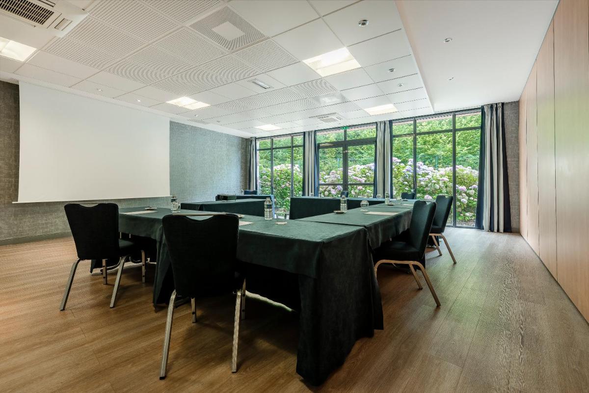 une salle de conférence avec une longue table et des chaises dans l'établissement Hôtel du Golf, à Lumbres
